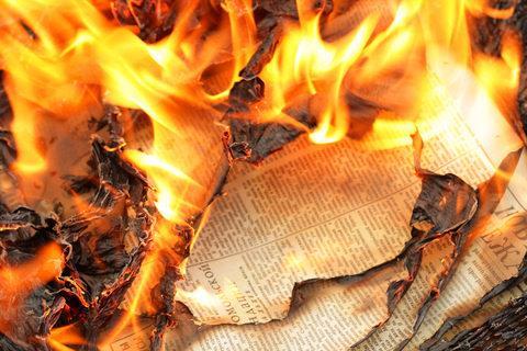 Several sheets of newspaper engulfed in flames