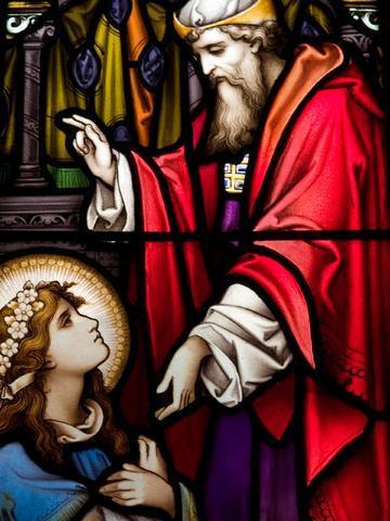 Stained glass of high priest with his right hand raised in blessing