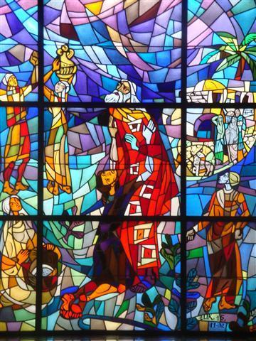 Modern stained glass depicting a son on his knees before his father