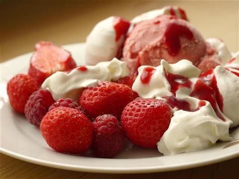 Plate of strawberries, raspberries, ice-cream, and whipped cream