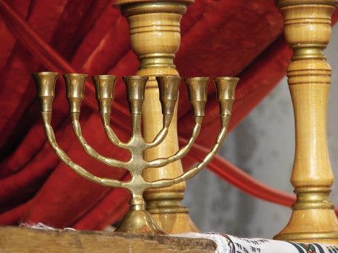Brass menorah in front of a red curtain