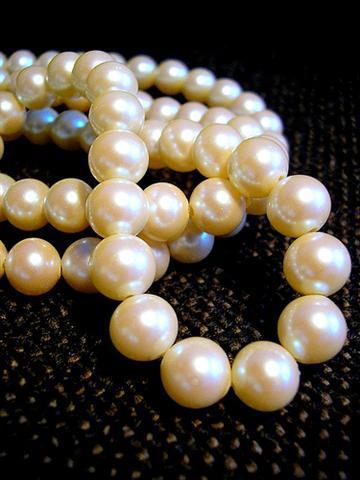 String of pearls set against a dark material background
