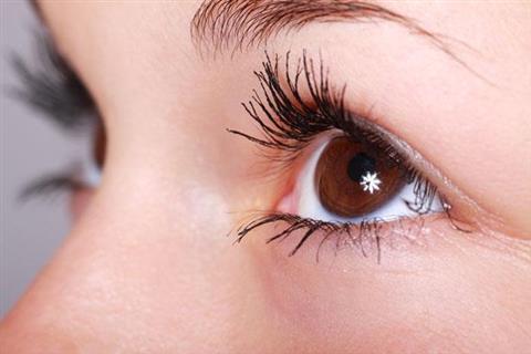 Close up of an hazel eye with long lashes and a prominent catchlight